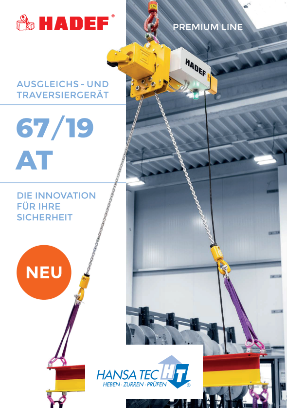 Ein gelbes Hebezeug hängt an Stahlseilen in einer modernen Industriehalle
